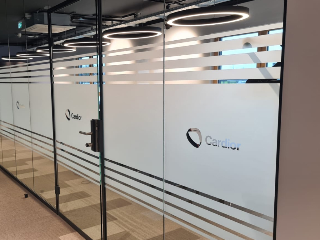 Milchglasstreifen mit ausgespartem Logo als Glasgestaltung.