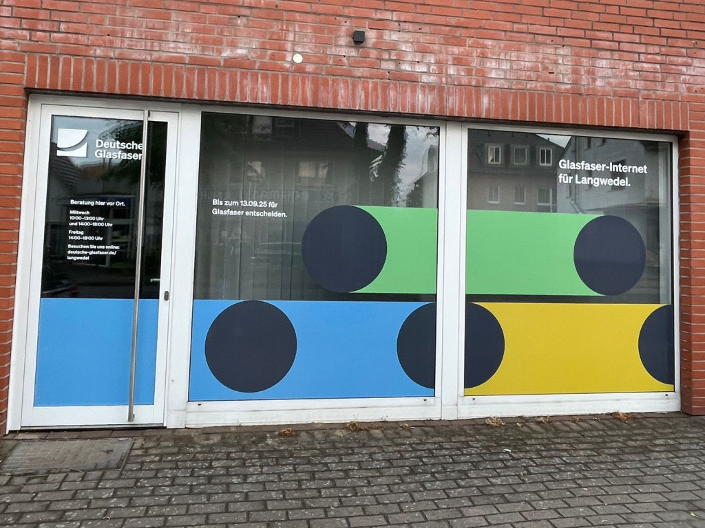 Farbige Fensterbeschriftung mit Logo und Öffnungszeiten.