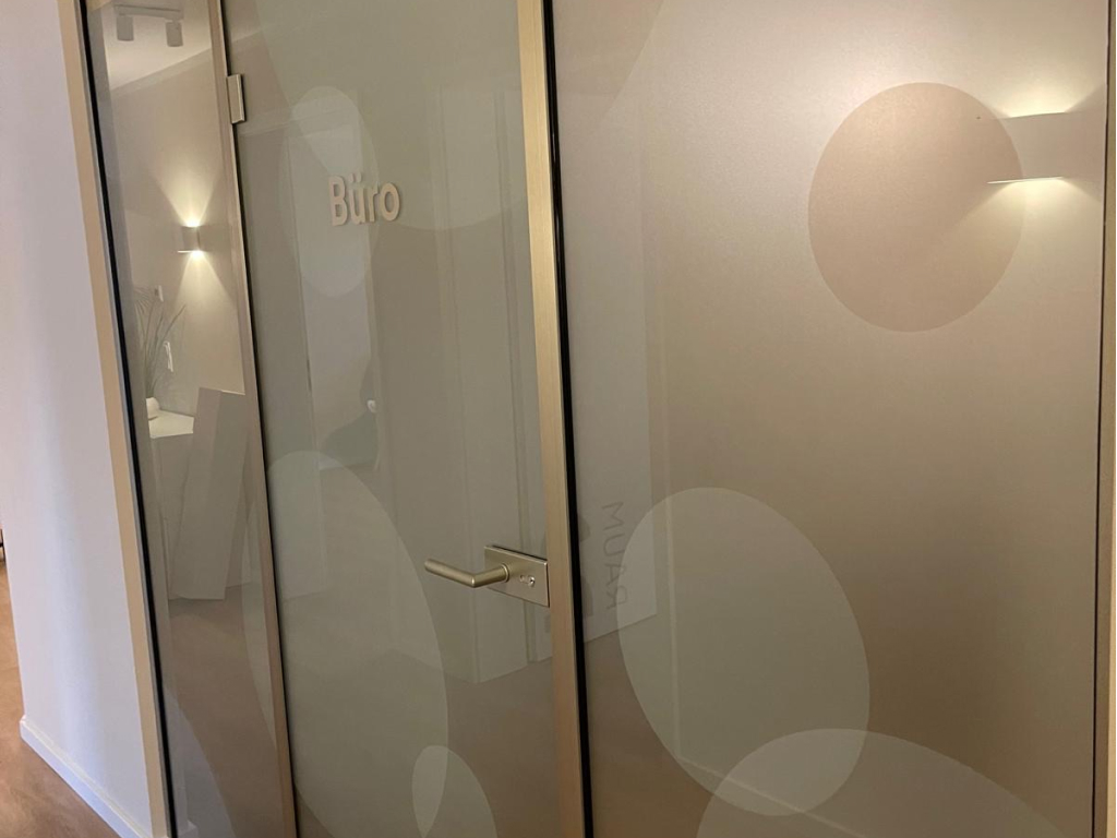 Bürotür mit Milchglasfolie und Beschriftung im Innenbereich.